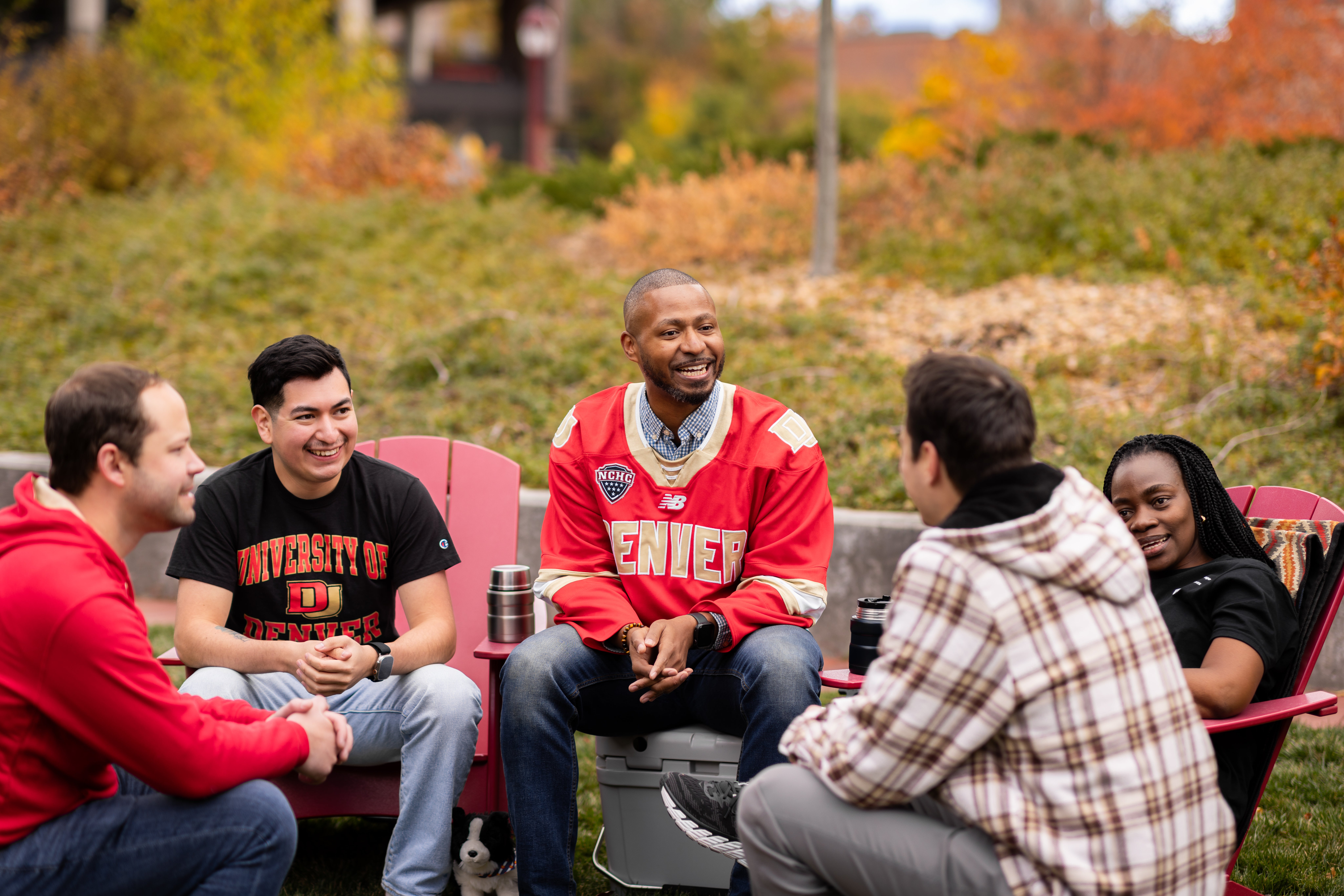 a small group sits and talks outside of Morgridge College