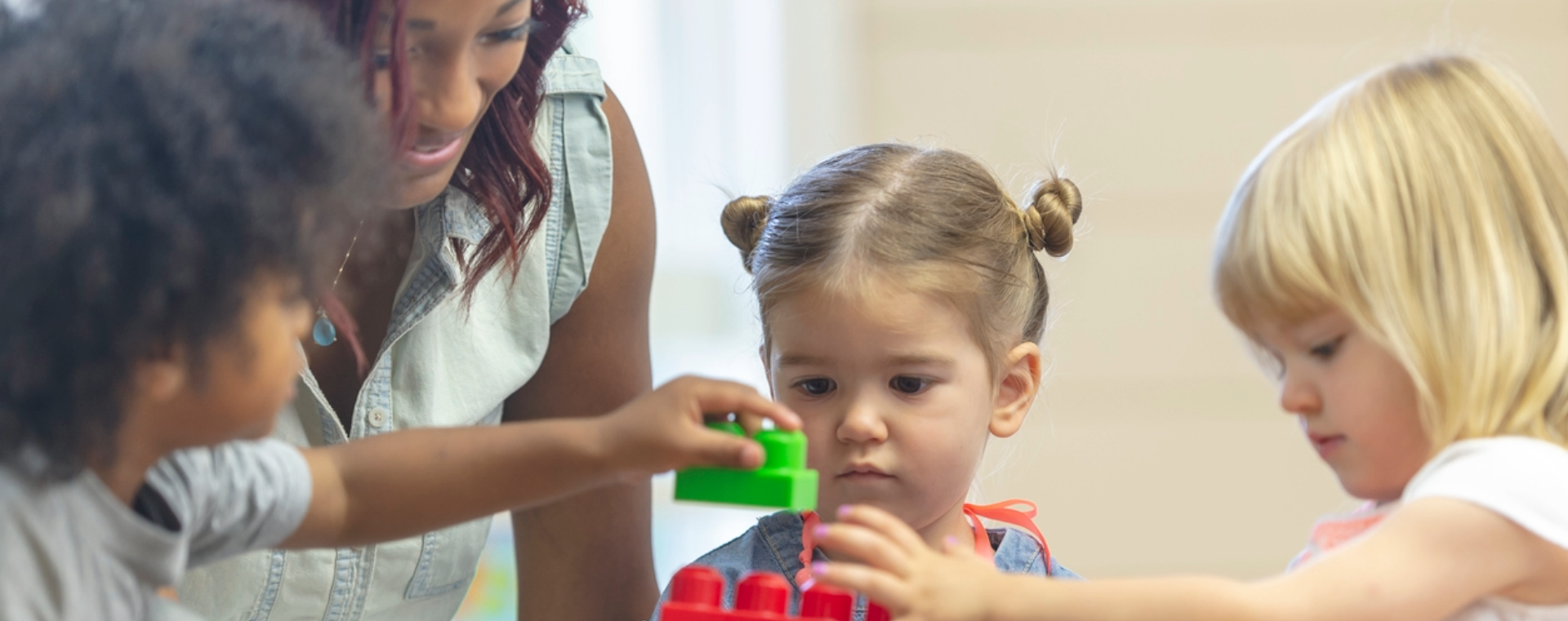 Children and teacher playing with blocks