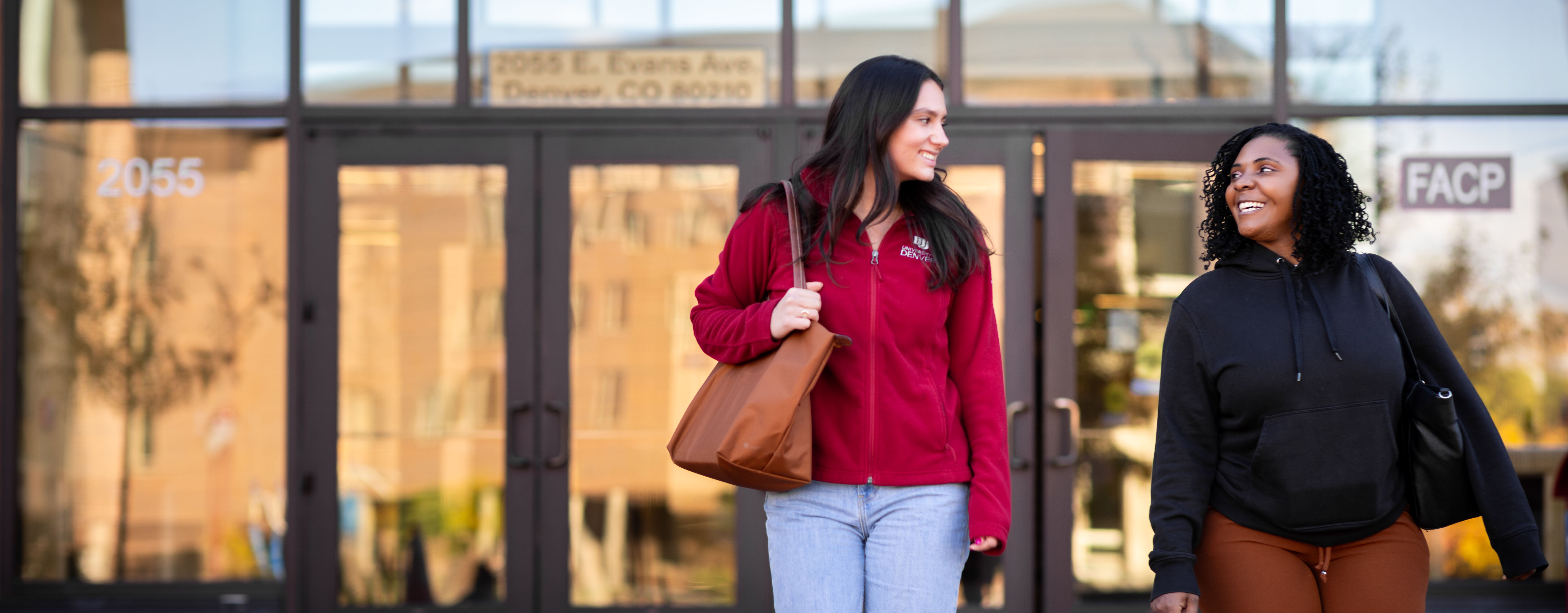 two students walk and talk on campus