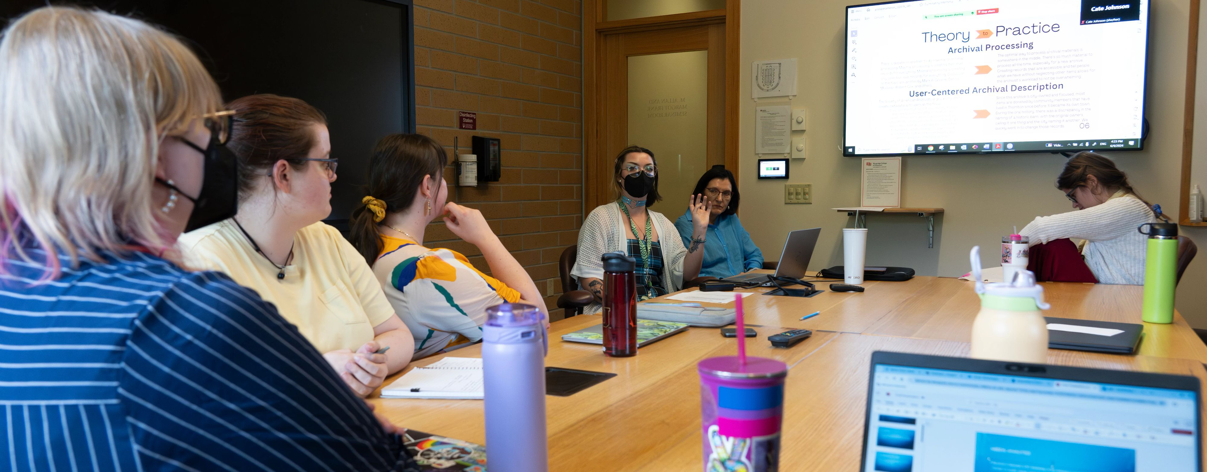 small group of students watch a presentation