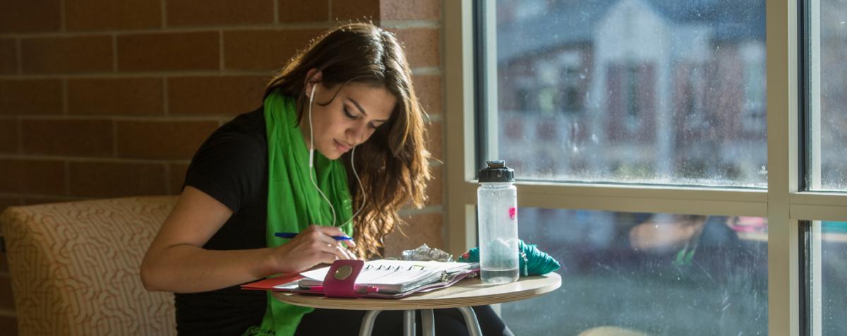 student sitting next to window looking at her calendar