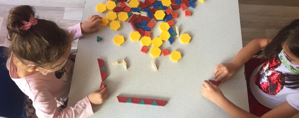 two children playing with pattern blocks