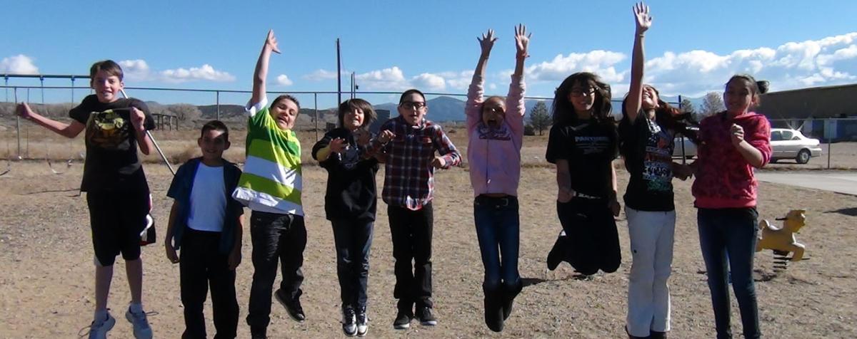 group of middle schoolers simultaneously jumping into the air