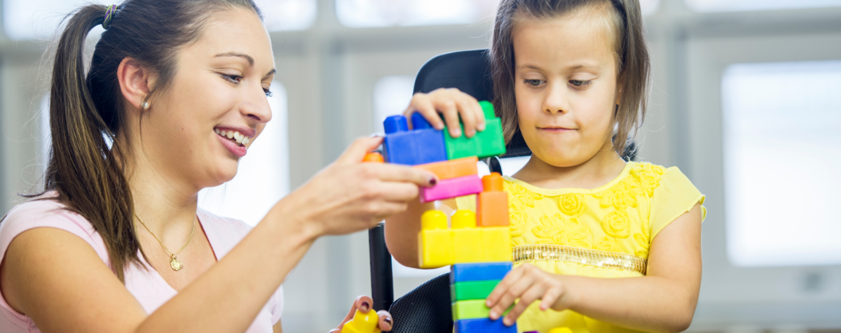 A teacher and child play with blocks